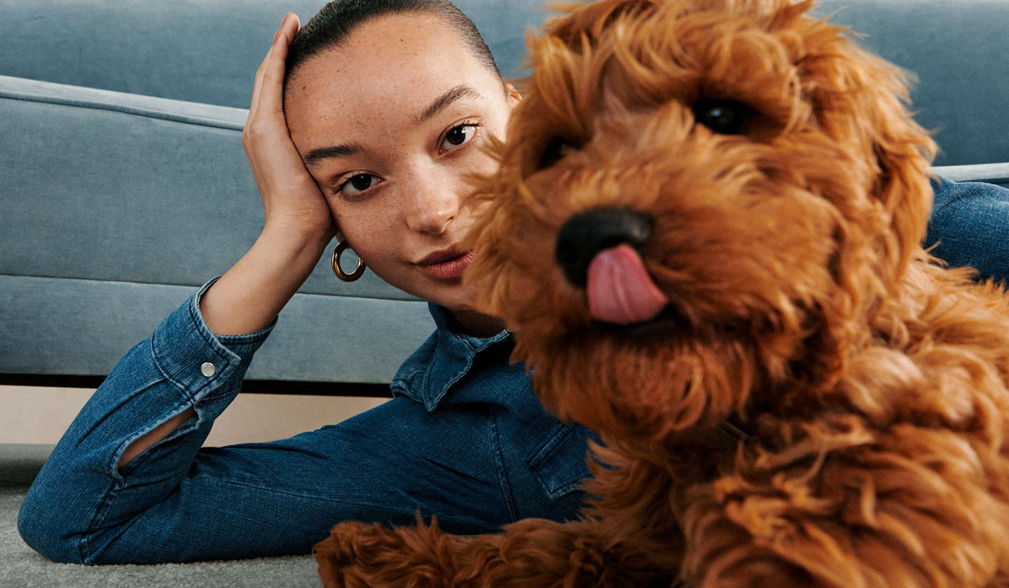 A woman taking a selfie with a puppy licking its nose. Galaxy Z Flip3 5G seen in Flex mode with the Camera app on the Main Screen, and the same photo seen in the viewfinder.